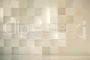 White painted concrete wall made of cubes with tiled floor