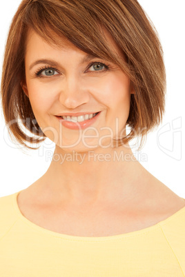 Adult brunette in yellow smiling at camera