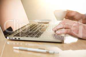 The hand on the keyboard and coffee