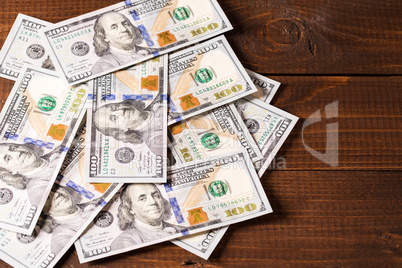 new 100 US dollars bills on wooden background