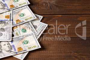 new 100 US dollars bills on wooden background