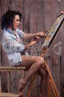 Female painter in different colors painting a picture