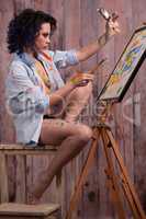 Female painter in different colors painting a picture