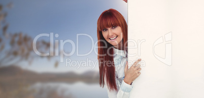 Composite image of smiling hipster woman behind a white card