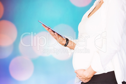 Composite image of midsection of pregnant woman using digital ta