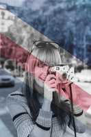 Composite image of smiling hipster woman taking pictures with a retro camera
