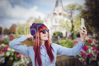 Composite image of smiling hipster woman taking selfie