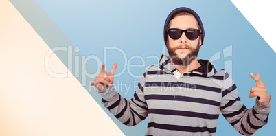 Composite image of hipster showing rock and roll hand sign