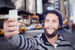 Composite image of happy hipster with hooded shirt taking selfie