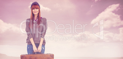 Composite image of smiling hipster woman holding suitcase