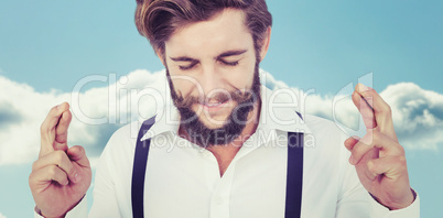 Composite image of hipster with fingers crossed