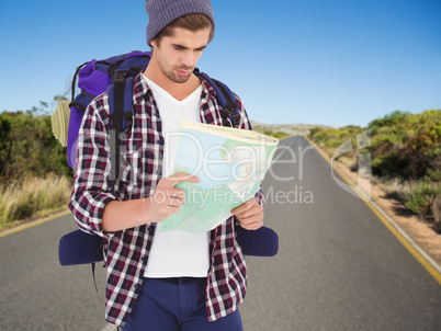 Composite image of man with backpack looking in map