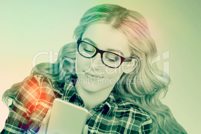 Composite image of gorgeous smiling blonde hipster using smartph