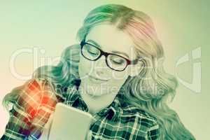 Composite image of gorgeous smiling blonde hipster using smartph