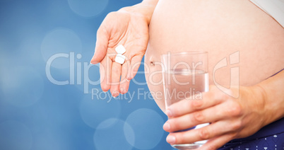 Composite image of pregnant woman taking a vitamin tablet