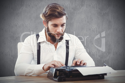 Composite image of hipster working on typewriter