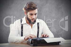 Composite image of hipster working on typewriter