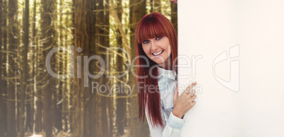 Composite image of smiling hipster woman behind a white card