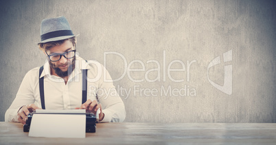 Composite image of hipster wearing eye glasses and hat working o