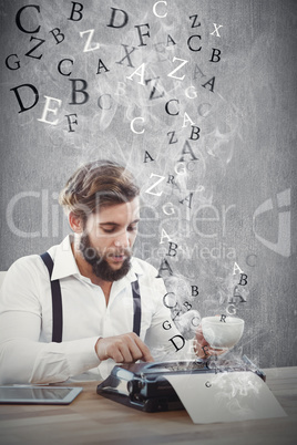 Composite image of hipster holding coffee working on typewriter