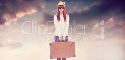 Composite image of portrait of a hipster woman holding suitcase