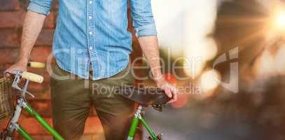 Composite image of portrait of hipster standing with bicycle