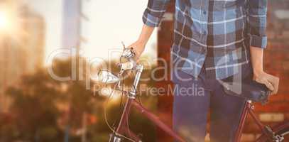 Composite image of portrait of hipster standing with bicycle