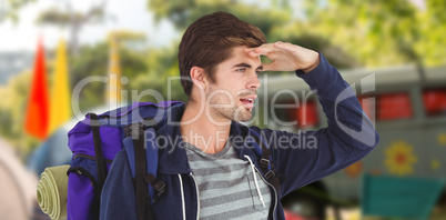 Composite image of man with backpack shielding eyes