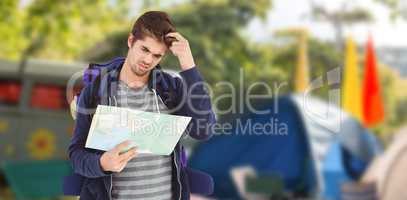Composite image of man scratching head while looking in map