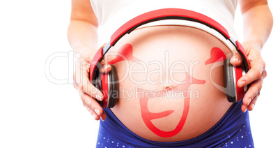 Composite image of pregnant woman holding earphones over bump