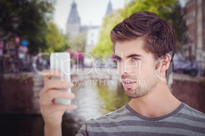 Composite image of man looking at mobile phonewhile standing