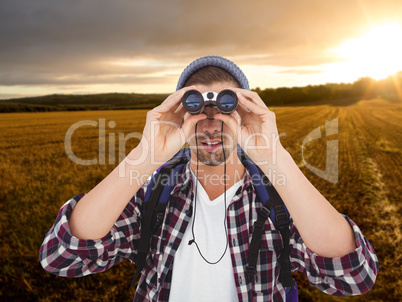 Composite image of hipster looking through binoculars