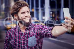Composite image of hipster taking selfie against wooden wall