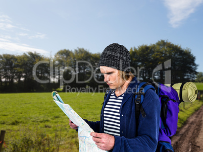 Composite image of backpacker looking a map