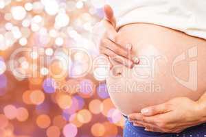 Composite image of pregnant woman with cream on bump