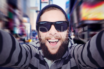 Composite image of portrait of happy hipster wearing sunglasses