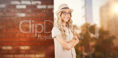 Composite image of gorgeous smiling blonde hipster with arms cro