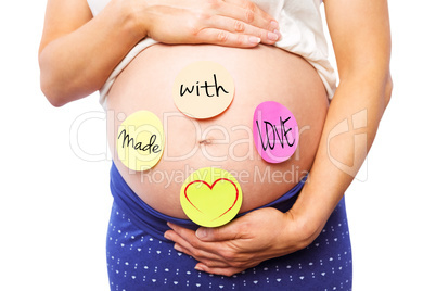 Composite image of pregnant woman with stickers on bump