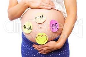 Composite image of pregnant woman with stickers on bump
