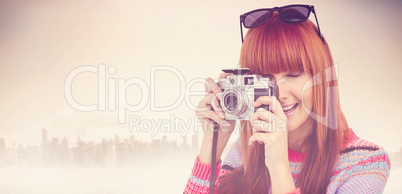 Composite image of smiling hipster woman taking pictures with a