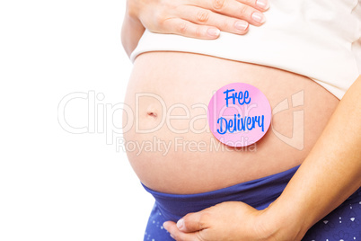 Composite image of pregnant woman with sticker on bump