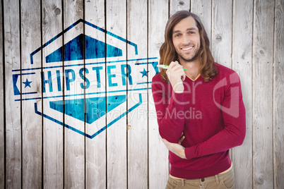 Composite image of portrait of happy hipster holding pen