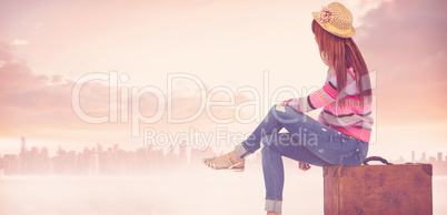 Composite image of hipster woman sitting on her suitcase