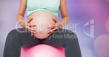 Composite image of pregnant woman sitting on pink exercise ball