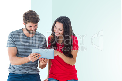 Composite image of happy couple using tablet