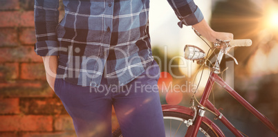 Composite image of mid section of hipster with bicycle