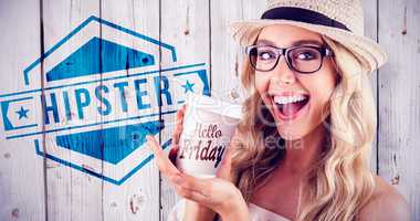 Composite image of gorgeous smiling blonde hipster presenting ta