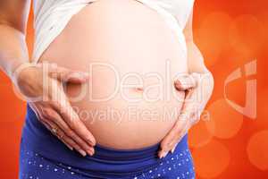 Composite image of pregnant woman holding her bump