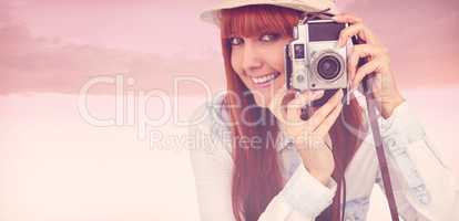 Composite image of attractive hipster photographing with camera