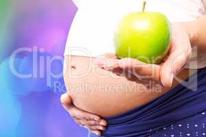 Composite image of pregnant woman holding green apple